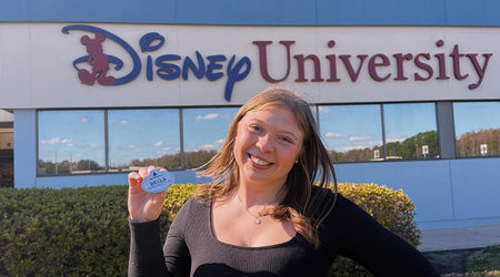 student holding Disney college program nametag outside of Disney University